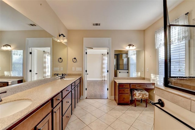 bathroom featuring plenty of natural light, tile patterned floors, vanity, and walk in shower