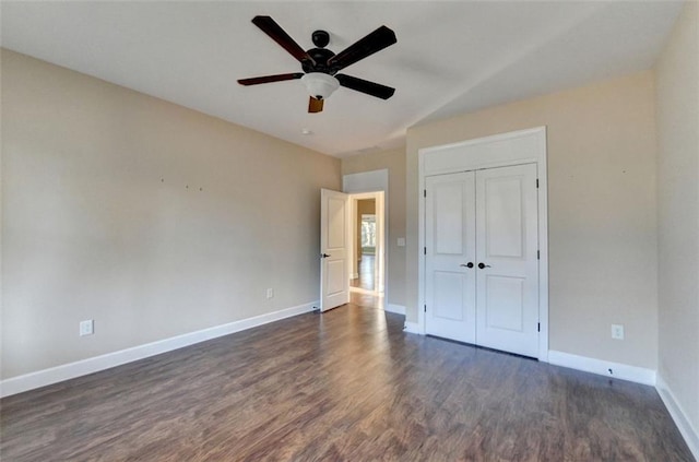 unfurnished bedroom featuring a closet, ceiling fan, and dark hardwood / wood-style flooring