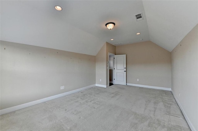 bonus room with light colored carpet and lofted ceiling