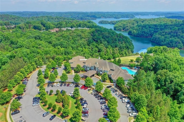 bird's eye view with a water view and a wooded view