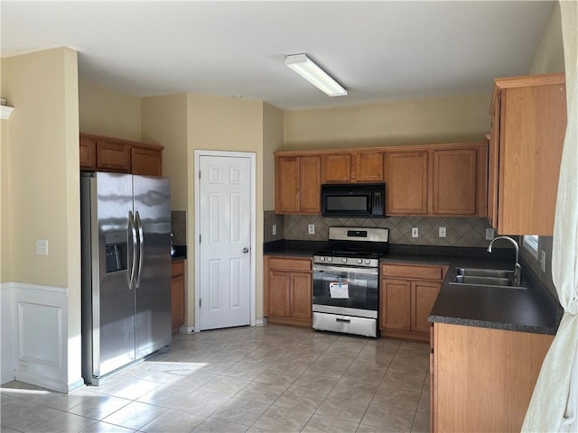 1963 Lakeshore Overlook Cir NW, Kennesaw, GA 30152 - kitchen featuring brown cabinetry, dark countertops, tasteful backsplash, a sink, and stainless steel appliances
