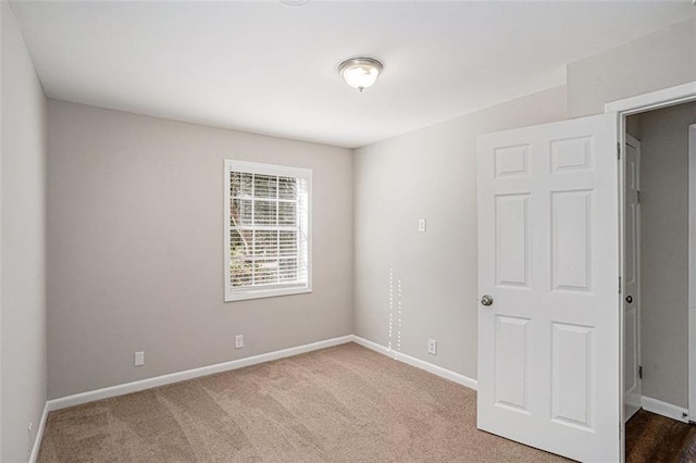 carpeted spare room featuring baseboards