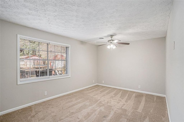 empty room featuring a textured ceiling, carpet, a ceiling fan, and baseboards