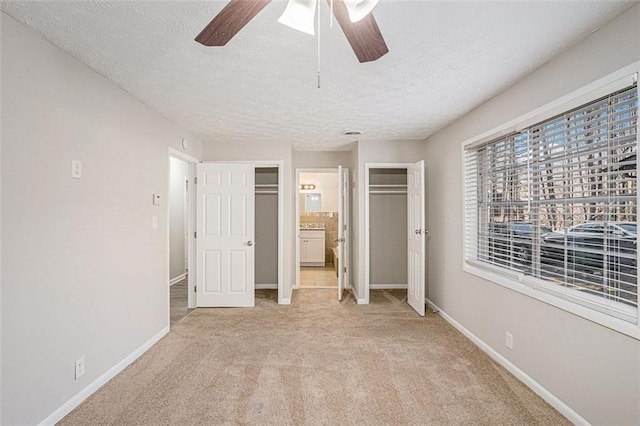 unfurnished bedroom with baseboards, a textured ceiling, and light colored carpet