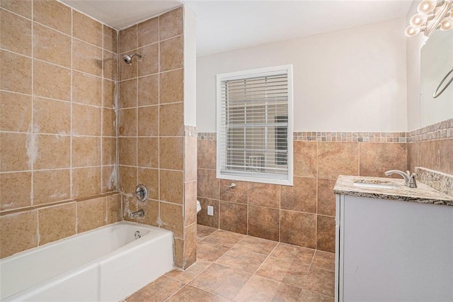 full bathroom with tub / shower combination, tile walls, vanity, and tile patterned floors