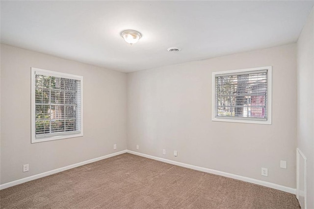 unfurnished room featuring a wealth of natural light, carpet flooring, and baseboards