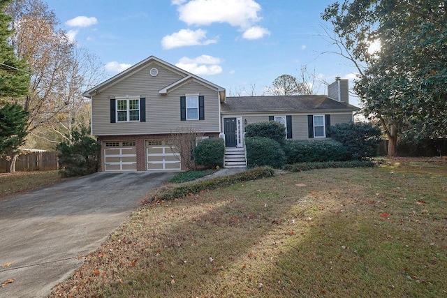 tri-level home featuring a garage and a front lawn