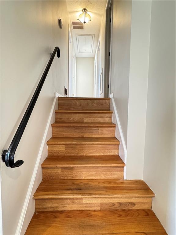 stairway featuring attic access and visible vents