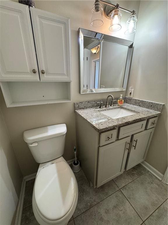 bathroom featuring tile patterned flooring, baseboards, vanity, and toilet