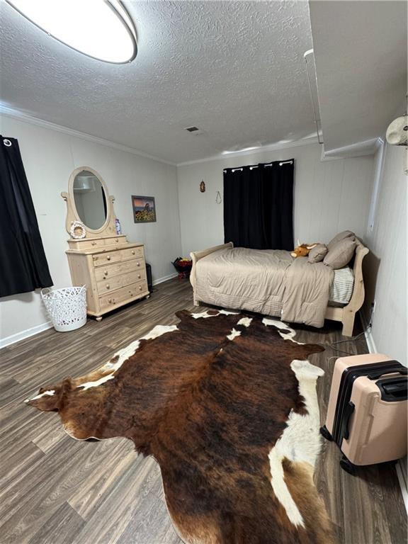 bedroom with a textured ceiling and wood finished floors