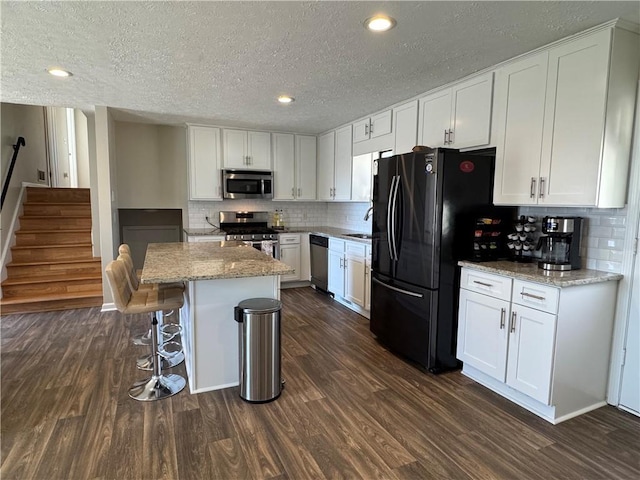 kitchen featuring white cabinets, appliances with stainless steel finishes, and dark wood finished floors