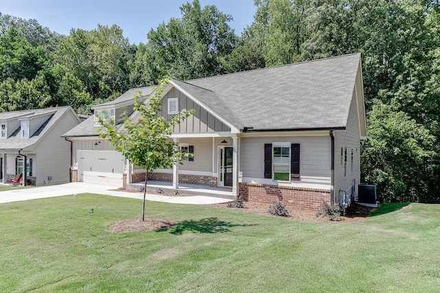 craftsman house featuring brick siding, covered porch, board and batten siding, a front yard, and driveway