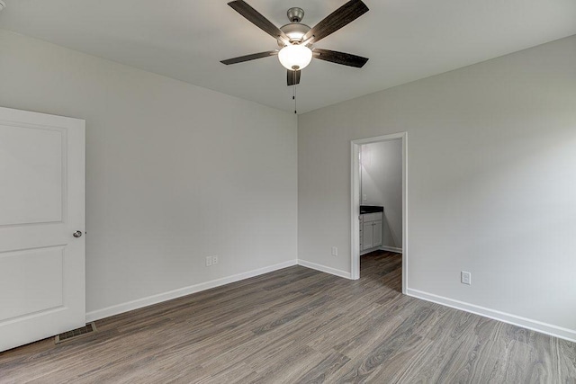 unfurnished room featuring ceiling fan, visible vents, baseboards, and wood finished floors