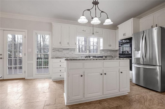 kitchen with white cabinetry, a kitchen island, and stainless steel fridge