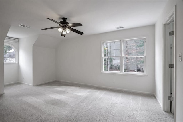 additional living space featuring vaulted ceiling, light carpet, and ceiling fan