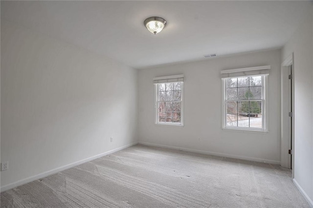 carpeted spare room featuring a wealth of natural light