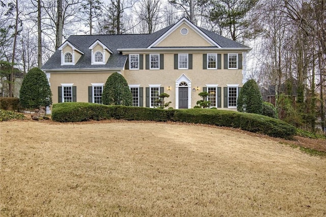 colonial-style house with a front lawn