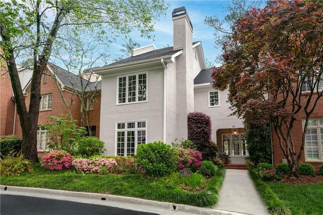 53 Paces W Dr NW, Atlanta, GA 30327 - view of front facade with a chimney, a shingled roof, and stucco siding