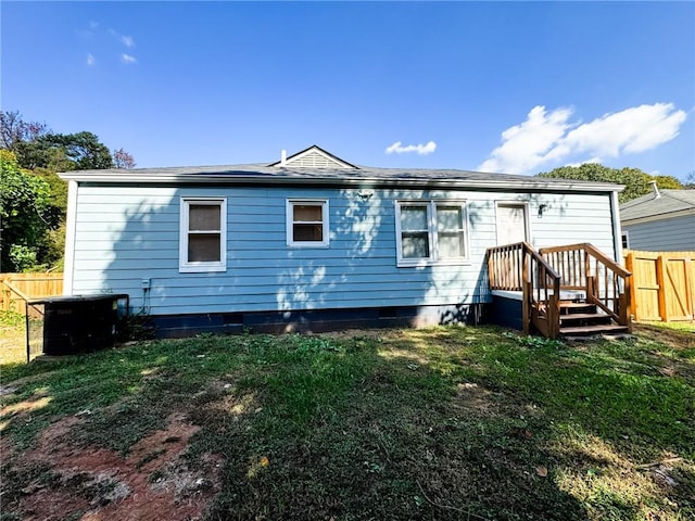 back of house featuring a wooden deck and a lawn