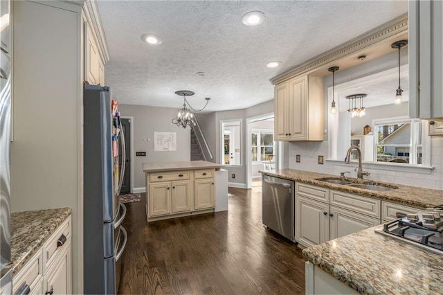 kitchen featuring dark hardwood / wood-style flooring, sink, decorative light fixtures, and appliances with stainless steel finishes