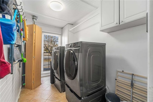 clothes washing area featuring cabinets, light tile patterned floors, and independent washer and dryer