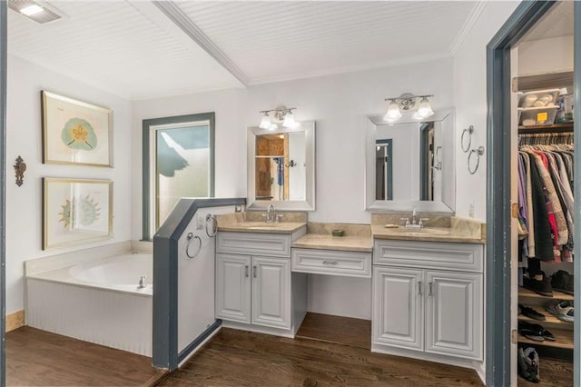 bathroom featuring wood-type flooring, a bathing tub, vanity, and crown molding