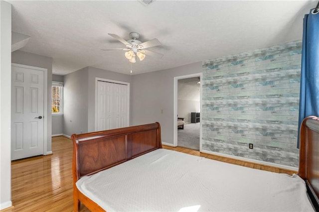 bedroom featuring ceiling fan, light hardwood / wood-style floors, and a closet