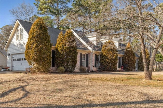 cape cod-style house with a garage and a front lawn