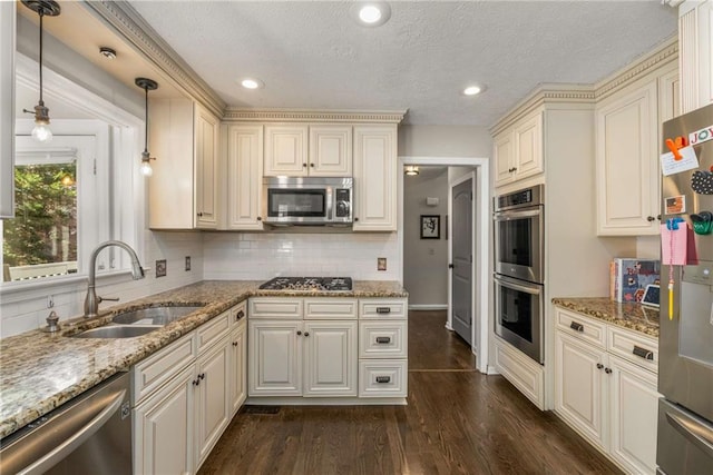 kitchen featuring sink, decorative light fixtures, dark hardwood / wood-style flooring, stone counters, and stainless steel appliances