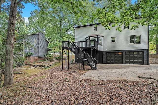 rear view of house with stairs, brick siding, an attached garage, and a wooden deck