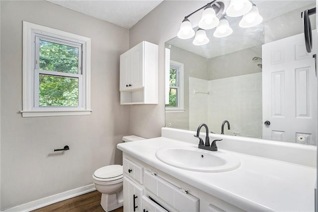 full bathroom featuring toilet, plenty of natural light, baseboards, and a shower