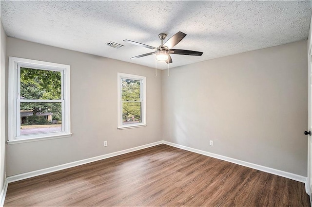 unfurnished room featuring visible vents, baseboards, and wood finished floors