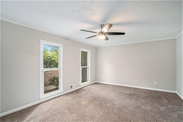 carpeted spare room with baseboards, visible vents, a ceiling fan, a textured ceiling, and crown molding