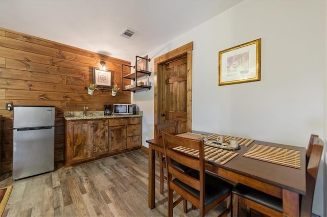 dining room featuring wooden walls and wood-type flooring