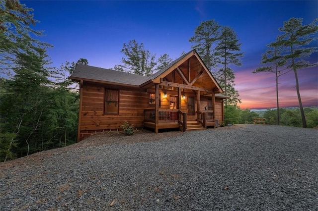 log home featuring covered porch