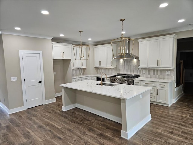kitchen with wall chimney range hood, dark wood-style floors, a kitchen island with sink, stainless steel range, and a sink