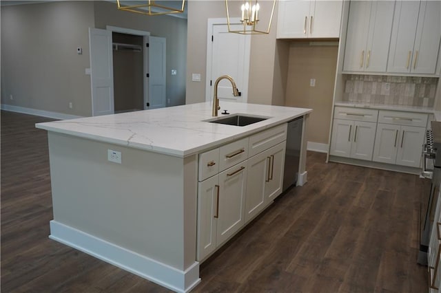 kitchen with baseboards, a sink, a chandelier, dark wood finished floors, and stainless steel dishwasher