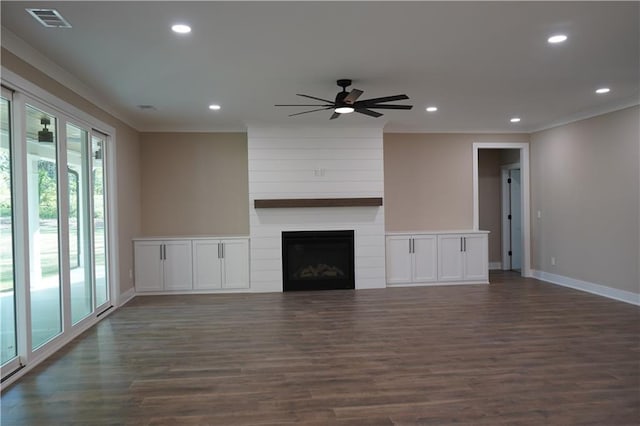 unfurnished living room featuring dark wood finished floors, ornamental molding, and recessed lighting