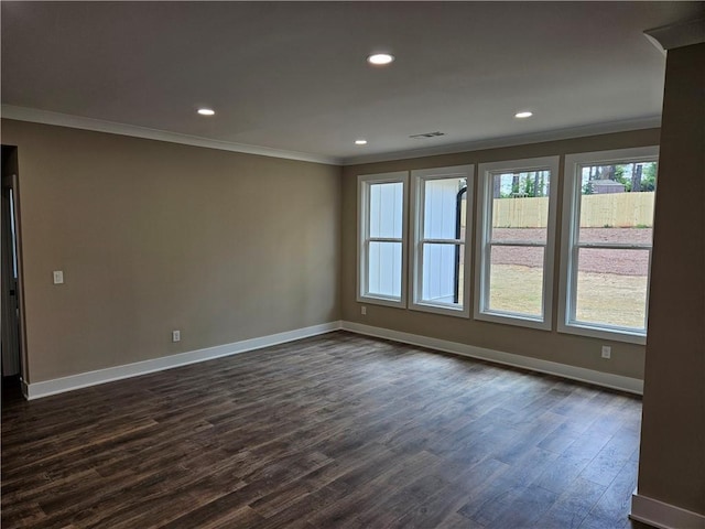 spare room featuring dark wood-type flooring, baseboards, ornamental molding, and recessed lighting