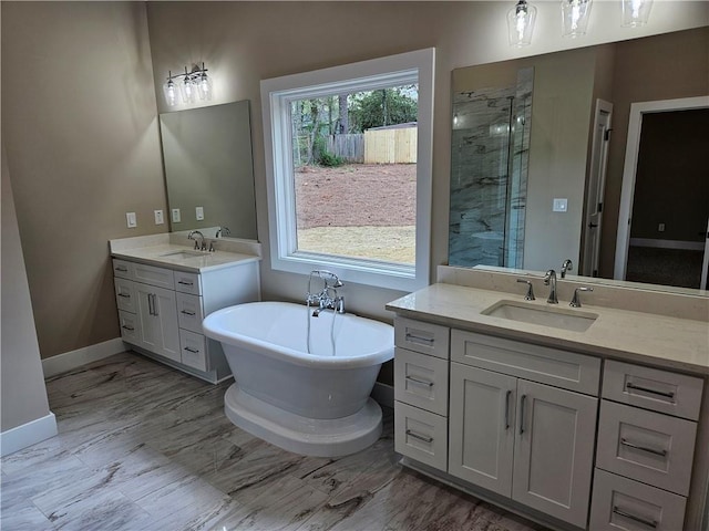 full bath with a sink, a soaking tub, two vanities, and a stall shower