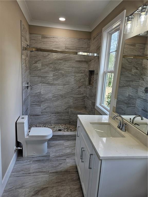 bathroom with toilet, vanity, ornamental molding, and a stall shower