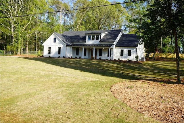 modern farmhouse with board and batten siding, metal roof, a standing seam roof, and a front lawn
