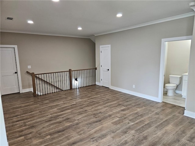empty room with ornamental molding, baseboards, and wood finished floors