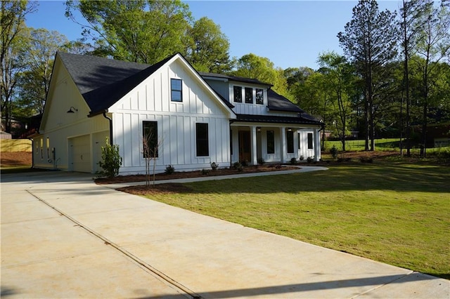 modern inspired farmhouse featuring board and batten siding, a front yard, an attached garage, and driveway