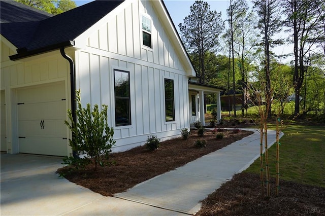 view of home's exterior featuring board and batten siding, a shingled roof, a garage, and concrete driveway