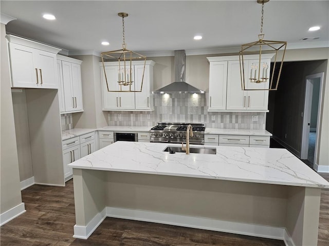 kitchen featuring a sink, decorative backsplash, an inviting chandelier, and wall chimney exhaust hood