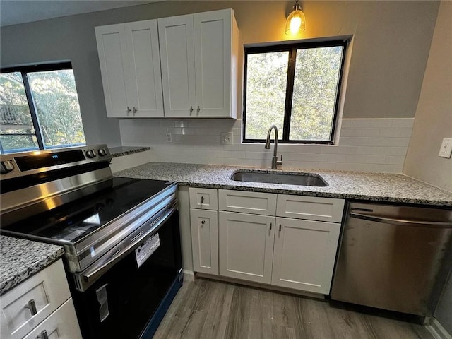 3932 Darryl Ln, Gainesville, GA 30506 - kitchen featuring tasteful backsplash, light stone countertops, light wood-type flooring, stainless steel appliances, and a sink