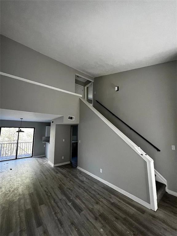 3932 Darryl Ln, Gainesville, GA 30506 - unfurnished living room featuring stairs, visible vents, wood finished floors, and baseboards