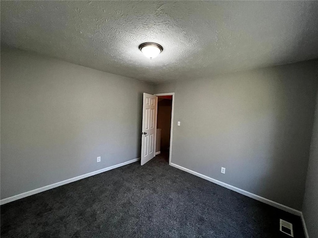 3932 Darryl Ln, Gainesville, GA 30506 - unfurnished room with dark colored carpet, visible vents, baseboards, and a textured ceiling
