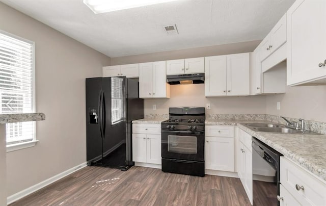 kitchen featuring a sink, black appliances, light countertops, under cabinet range hood, and white cabinetry